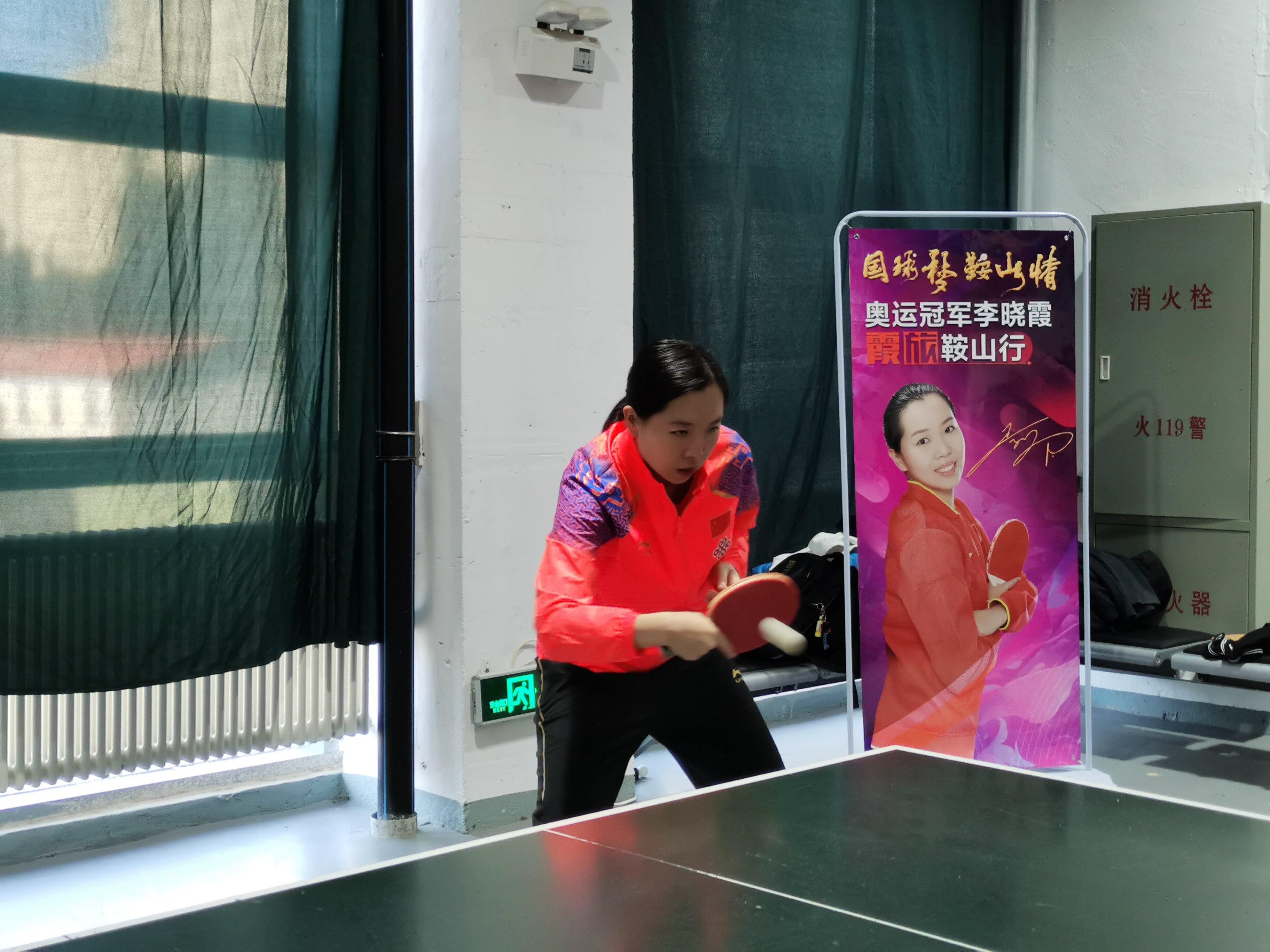 奥运冠军李晓霞与学生切磋球技。