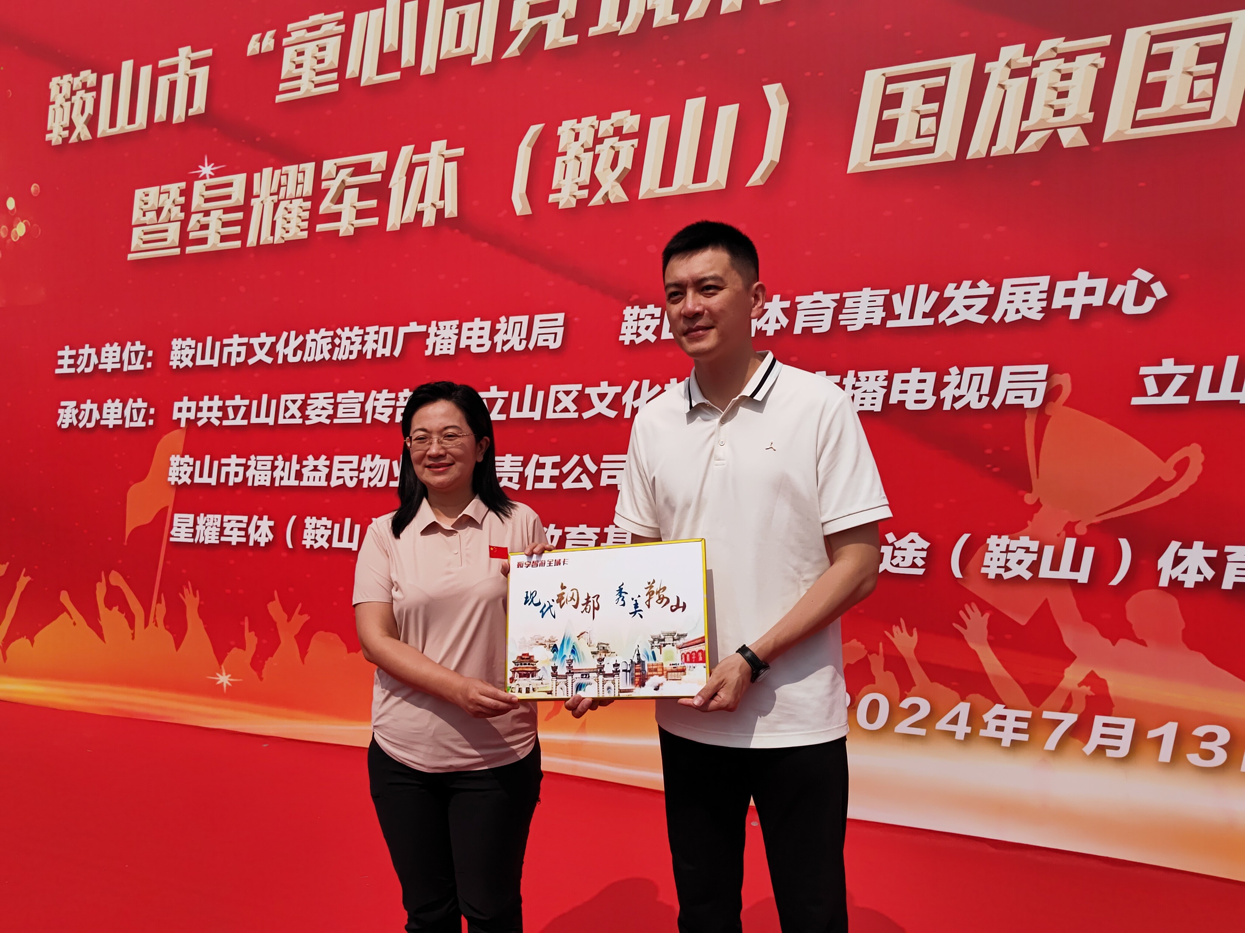 鞍山市文化旅游和广播电视局局长赵萍为杨鸣赠送全域旅游卡