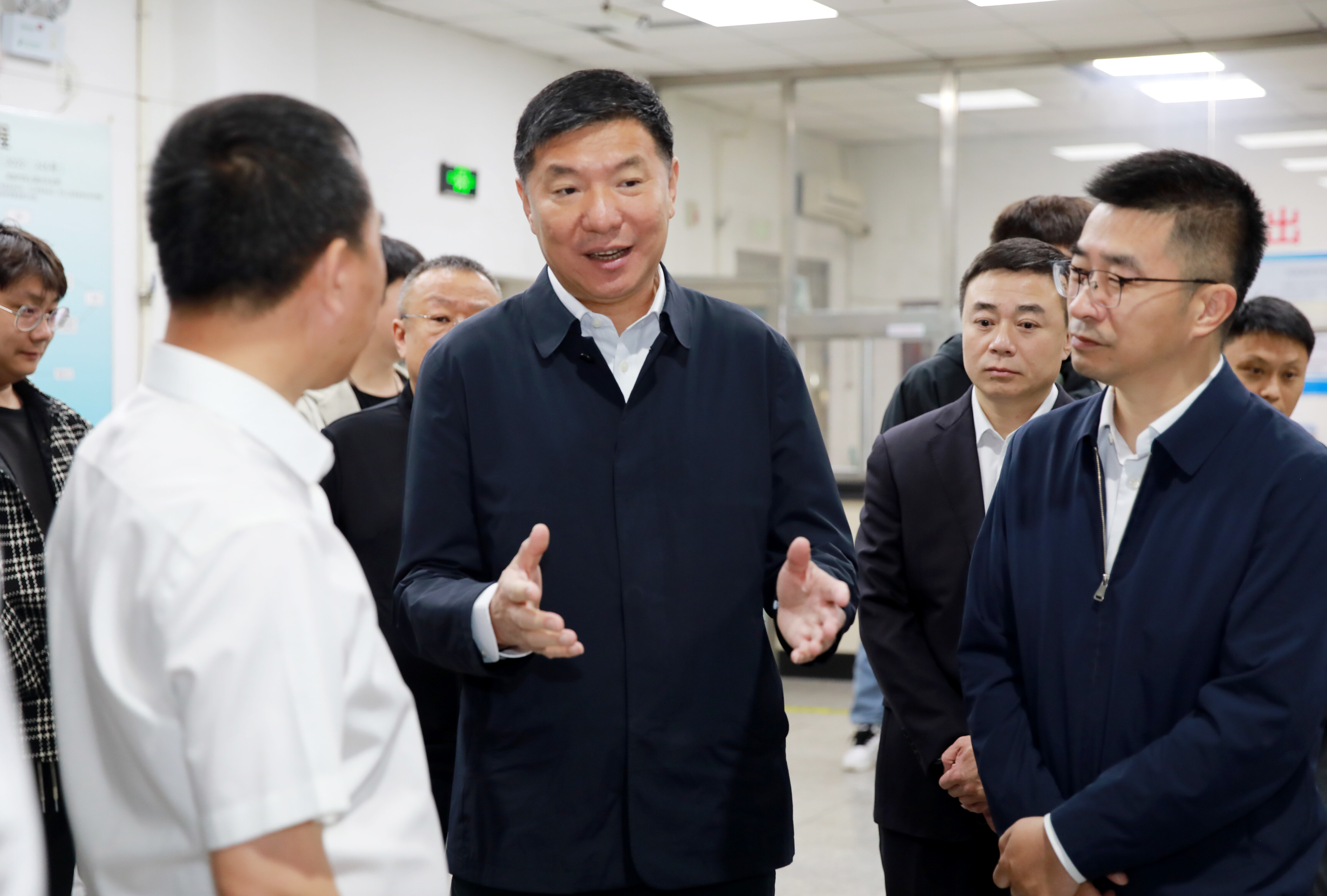 王忠昆参观技工院校展示区，与院校负责人互动交流。