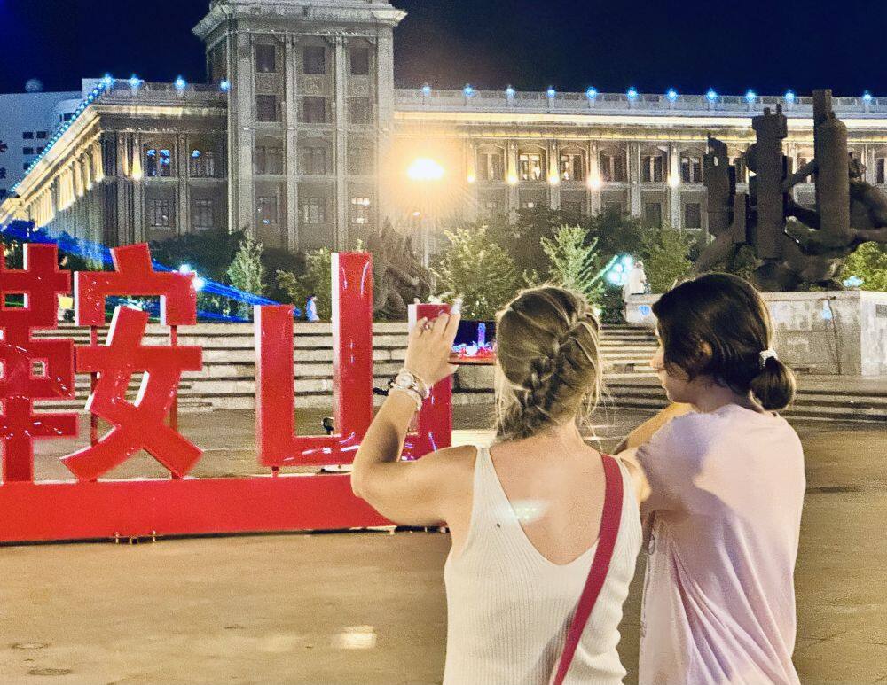 7月4日，留学生在鞍山市铁东区胜利广场拍照。新华社记者 吴青昊 摄