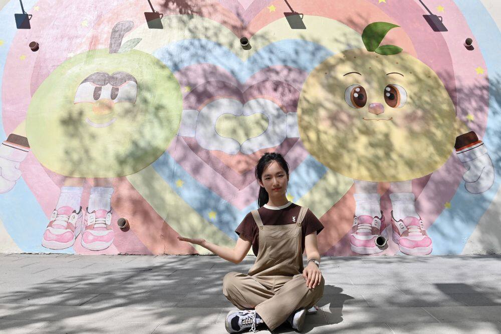 7月22日，四川美术学院学生陶心谛展示自己参与创作的墙绘。新华社记者 吴青昊 摄