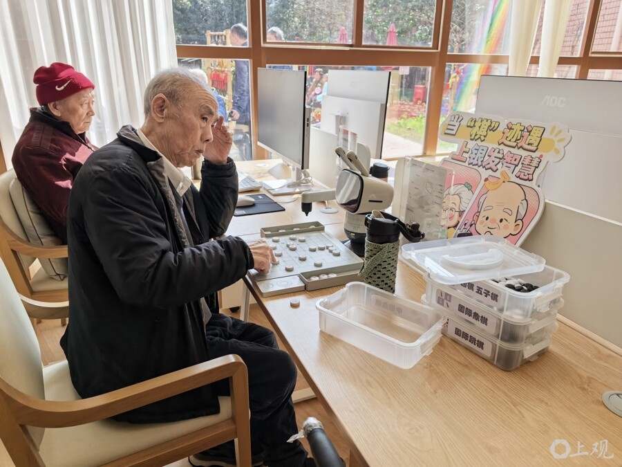 老人正在和机器人下棋、看视频。周楠 摄 老人正在和机器人下棋、看视频。周楠 摄