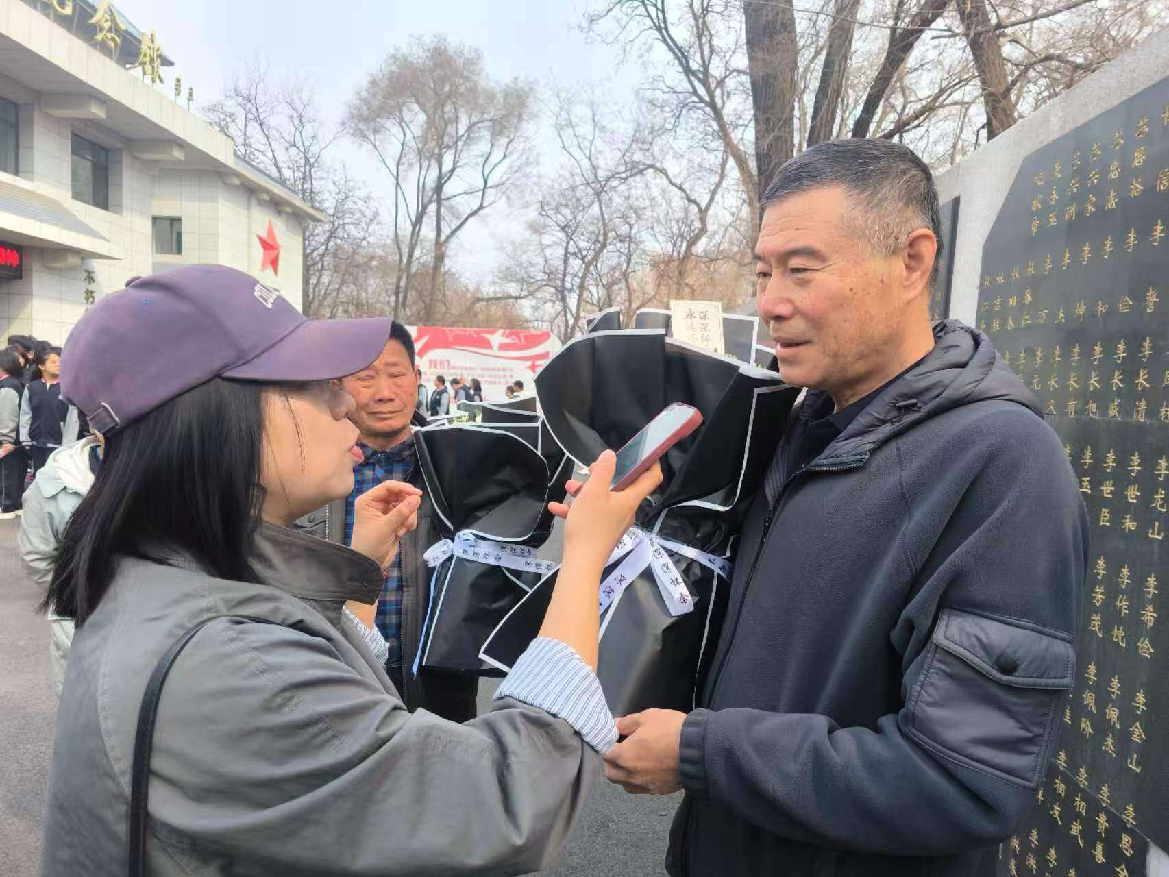 4月3日在杨宁的努力和鞍山烈士陵园的帮助下，营口籍烈士杜吉胜的侄孙后代来到鞍山祭拜。70多年后，杜吉胜烈士终于与家人“团圆”。左一为记者在现场采访