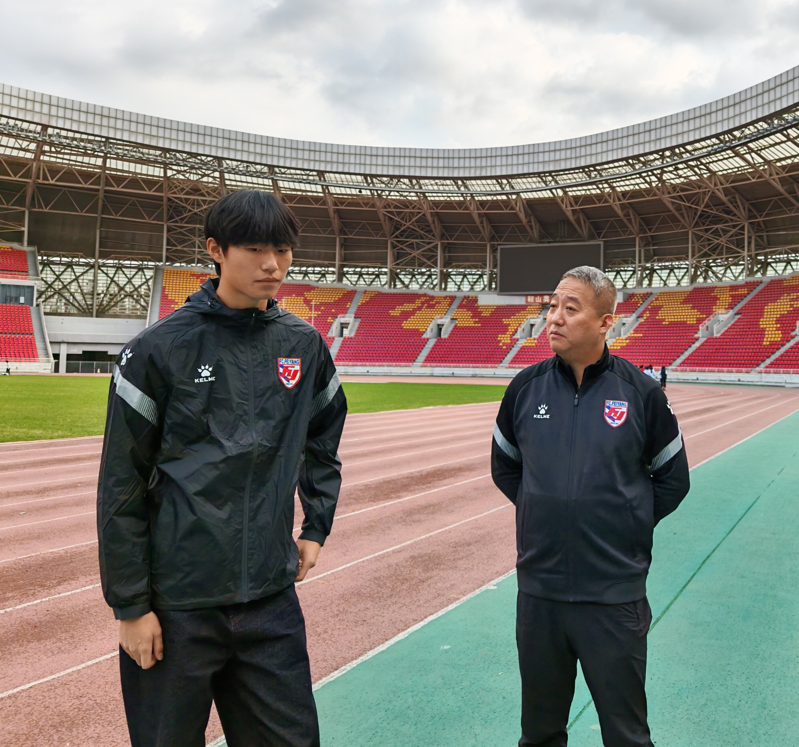 鞠铭泽（左）与启蒙教练夏明阳交流