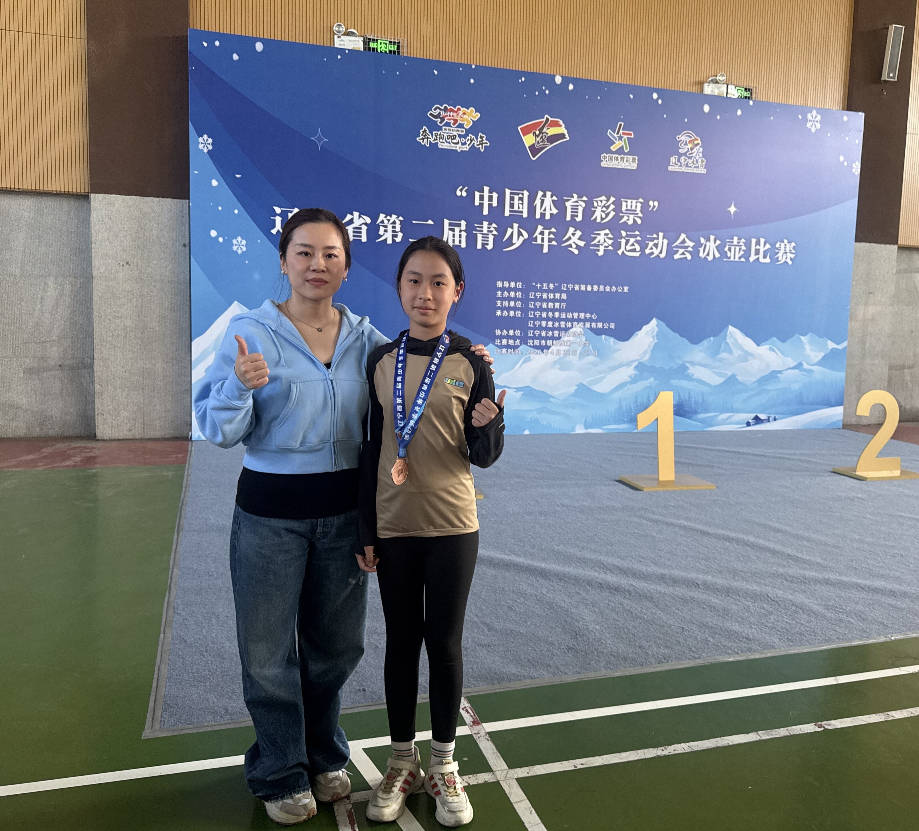 中国女子冰壶队队长王芮（左）与鞍山队队员合影