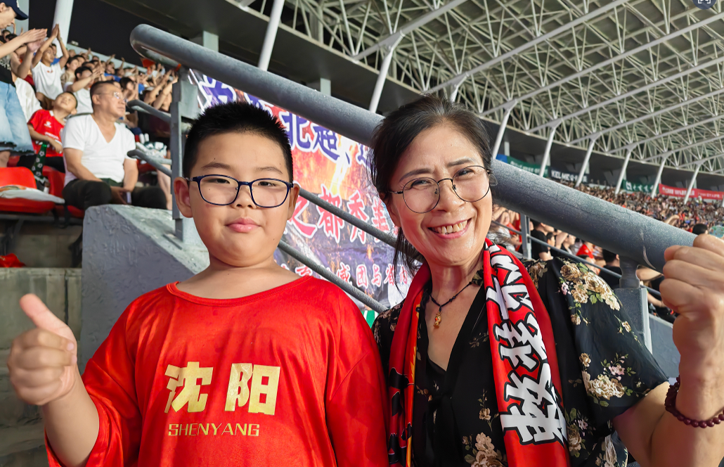 小球迷欧丁和姥姥一起观赛