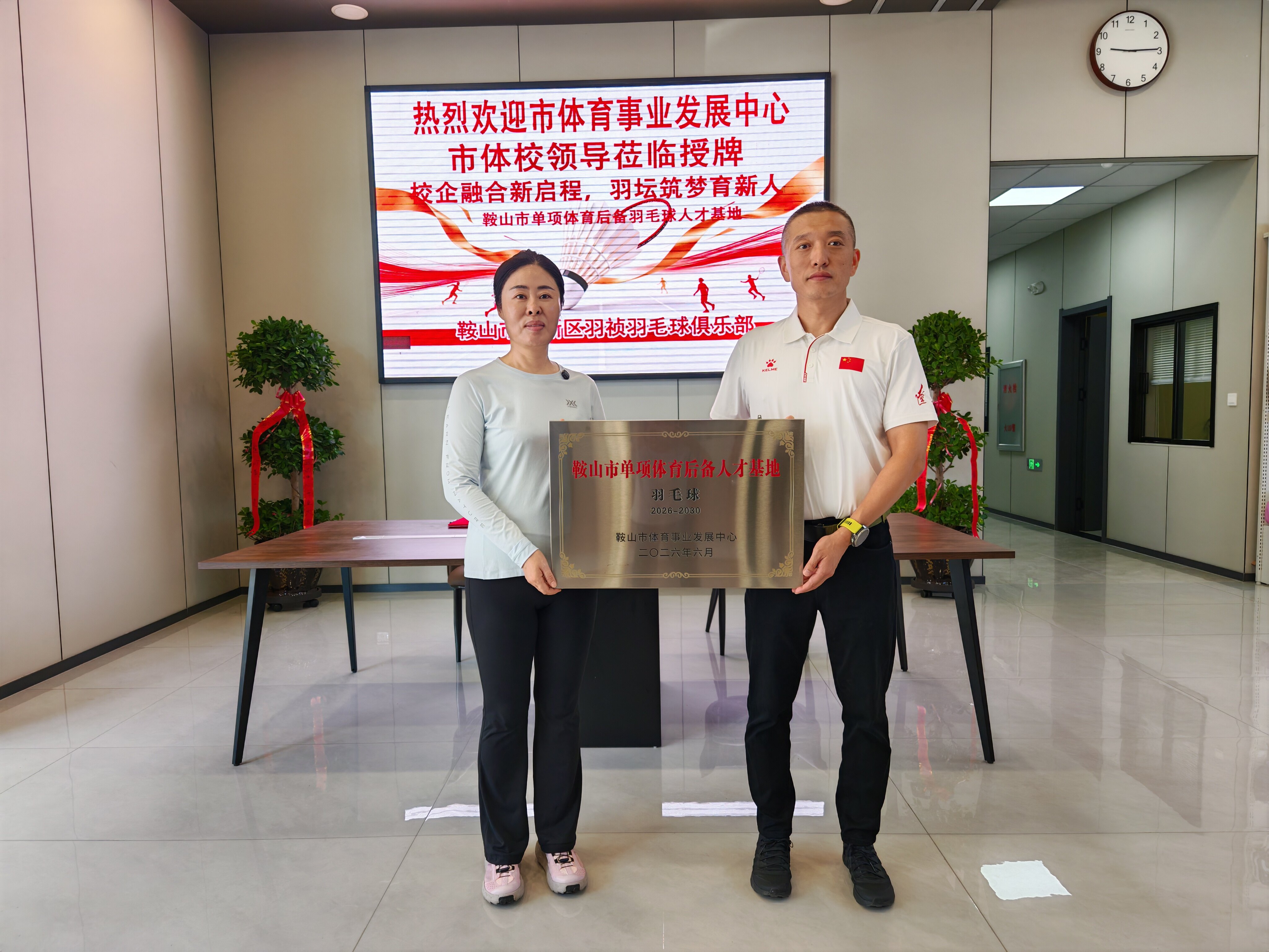 市体育事业发展中心领导（右）与羽毛球俱乐部负责人合影
